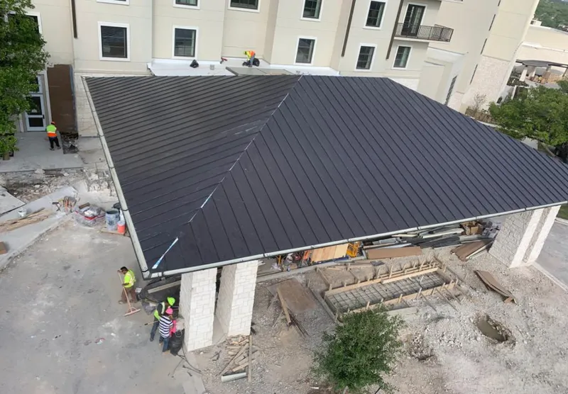 Metal roofing installation team working on a commercial building in Harrison
